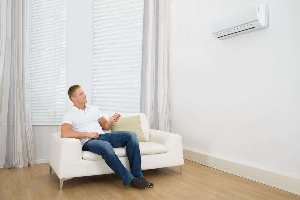 Man siting on sofa with air conditioner
