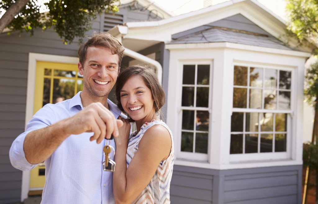 a couple holding their key to their new house