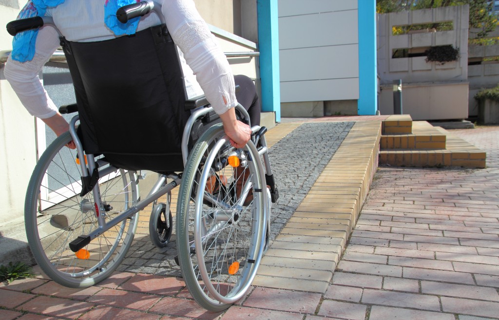 man in his wheelchair going up the disabled ramp