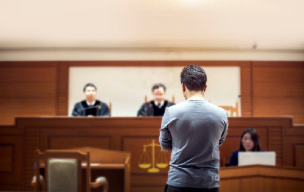 person in front of judges at the courtroom