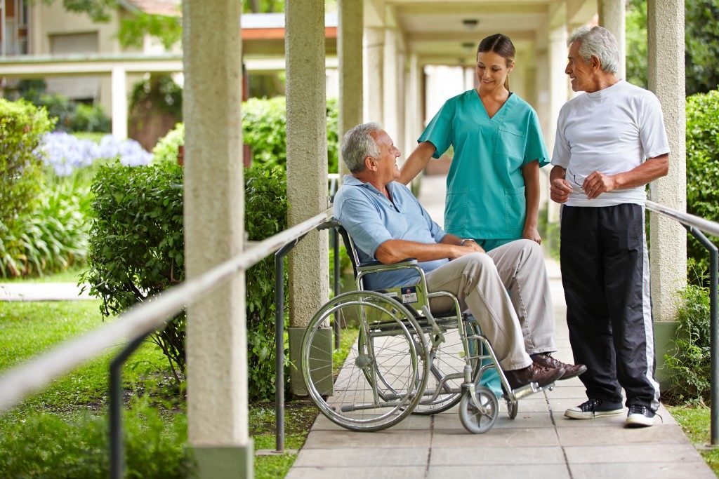 Two senior citizens talking to a nurse