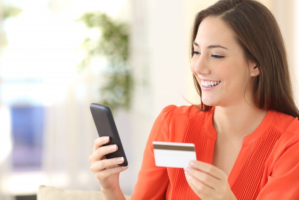 woman purchasing online while holding credit card